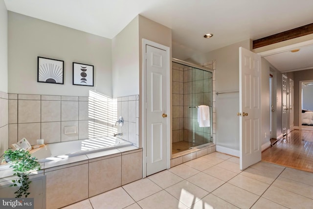 bathroom with beam ceiling, independent shower and bath, and hardwood / wood-style flooring