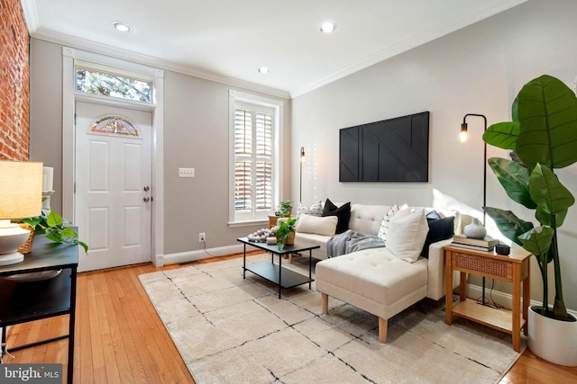 living room with light hardwood / wood-style floors, crown molding, and a wealth of natural light