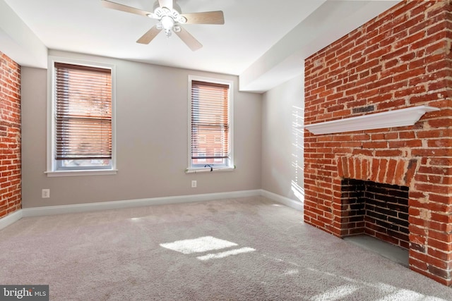 unfurnished living room featuring ceiling fan, light colored carpet, and a brick fireplace