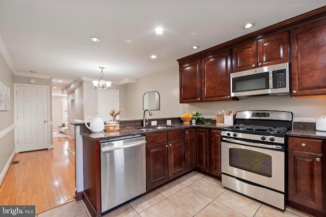 kitchen with sink, hanging light fixtures, light hardwood / wood-style flooring, ornamental molding, and stainless steel appliances