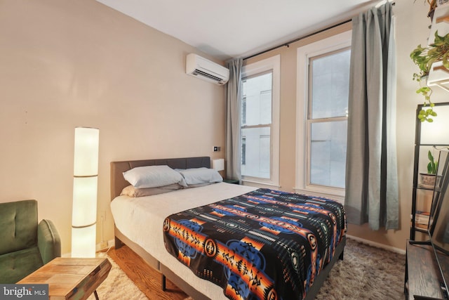 bedroom with a wall unit AC and baseboards