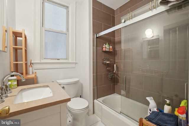 full bathroom with visible vents, shower / bath combination with glass door, vanity, and toilet