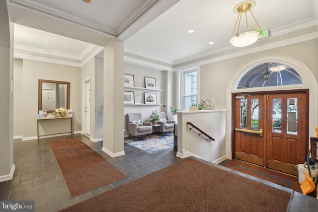 entryway featuring baseboards, stone tile flooring, a wealth of natural light, and crown molding