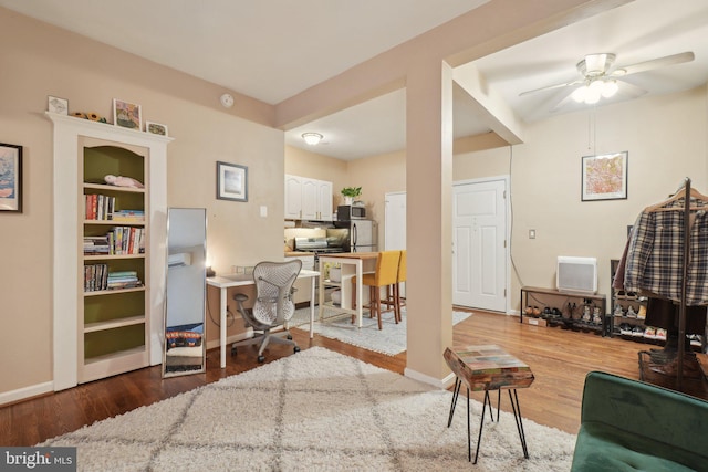 interior space featuring ceiling fan, baseboards, and wood finished floors