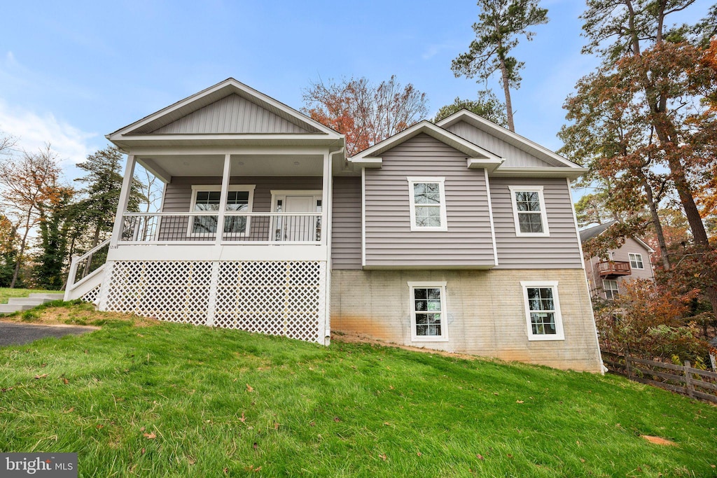 back of house featuring a yard and a porch