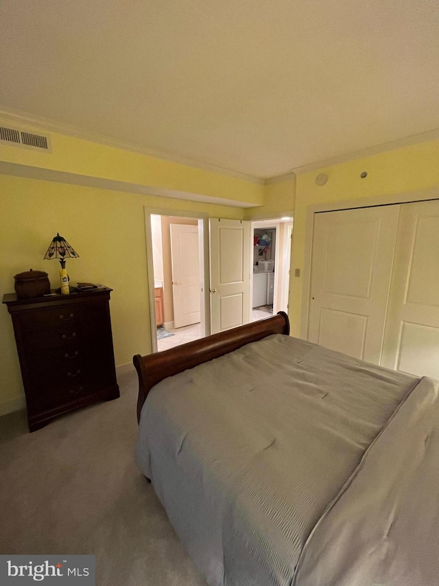 carpeted bedroom with washer / clothes dryer, a closet, and ornamental molding