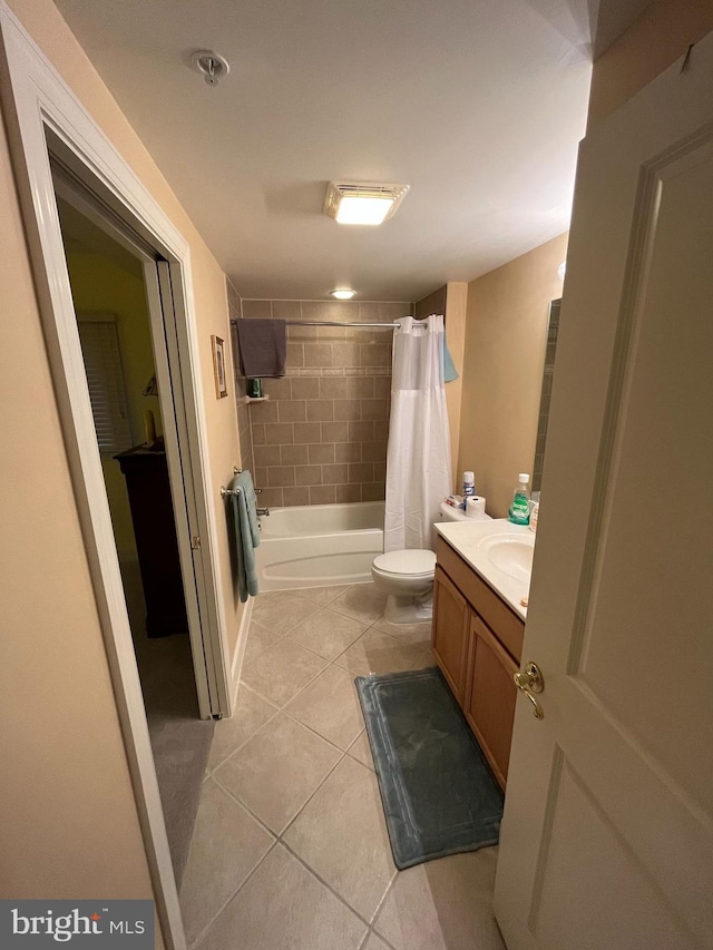 full bathroom featuring tile patterned flooring, shower / bath combination with curtain, vanity, and toilet