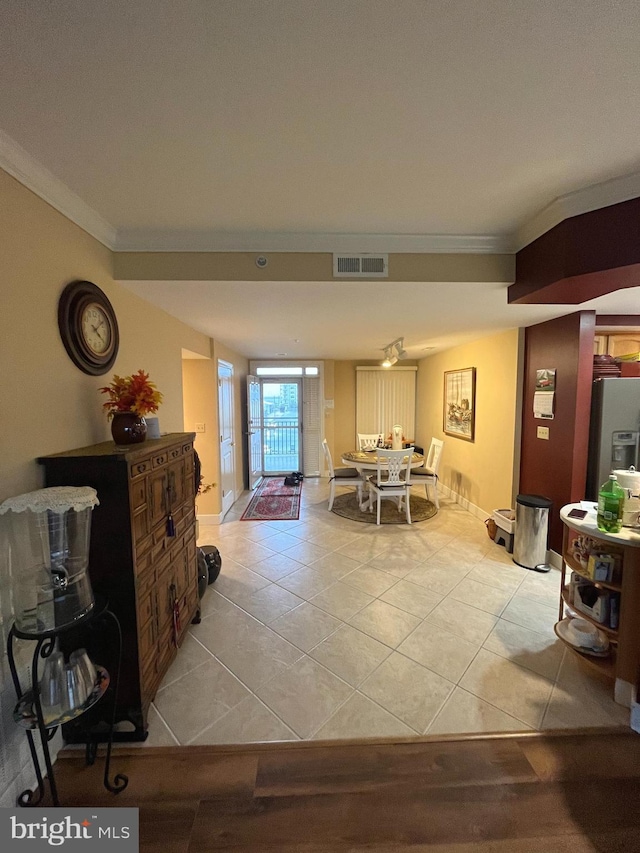 dining area with light tile patterned flooring and ornamental molding