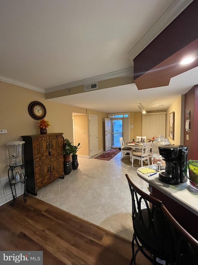 dining space featuring crown molding and light tile patterned flooring