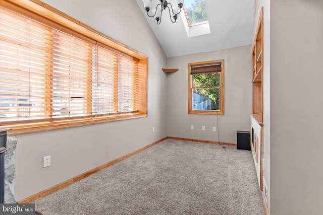 carpeted spare room featuring lofted ceiling with skylight