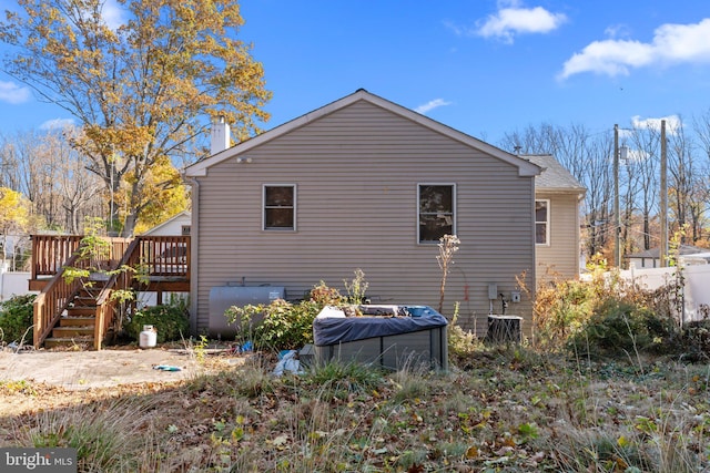 view of side of home with central AC unit and a deck