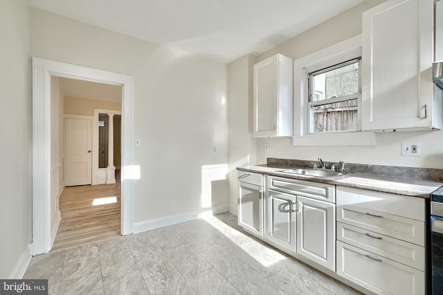 kitchen featuring white cabinets, white range with electric stovetop, light hardwood / wood-style flooring, and sink