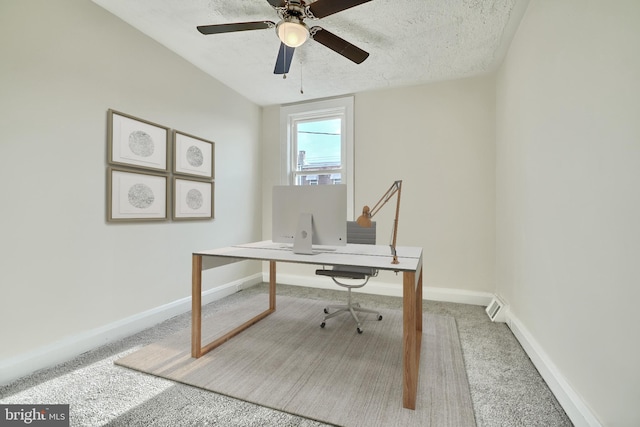 carpeted home office featuring ceiling fan and a textured ceiling