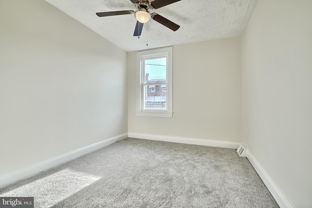 spare room featuring a textured ceiling, carpet floors, ceiling fan, and lofted ceiling