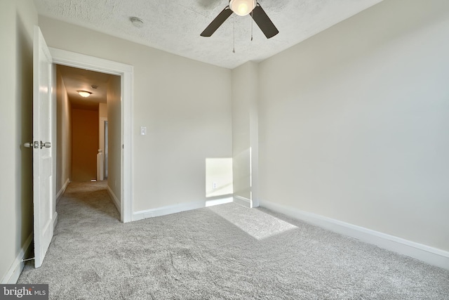 carpeted spare room featuring ceiling fan and a textured ceiling