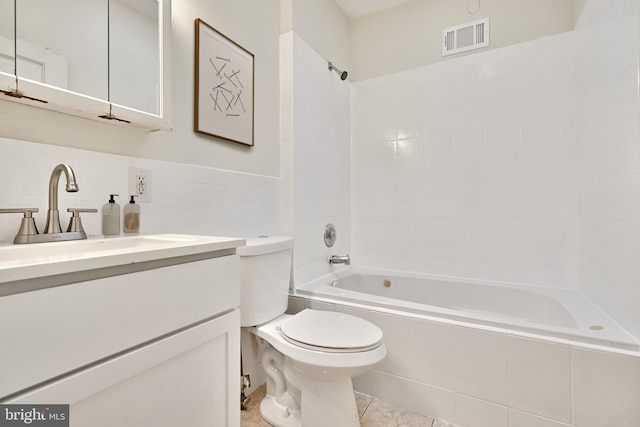 full bathroom featuring toilet, tile patterned floors, vanity, and tiled shower / bath combo