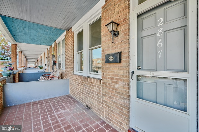 view of exterior entry featuring covered porch