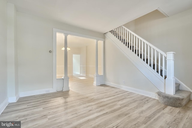 stairway with hardwood / wood-style flooring and ornate columns