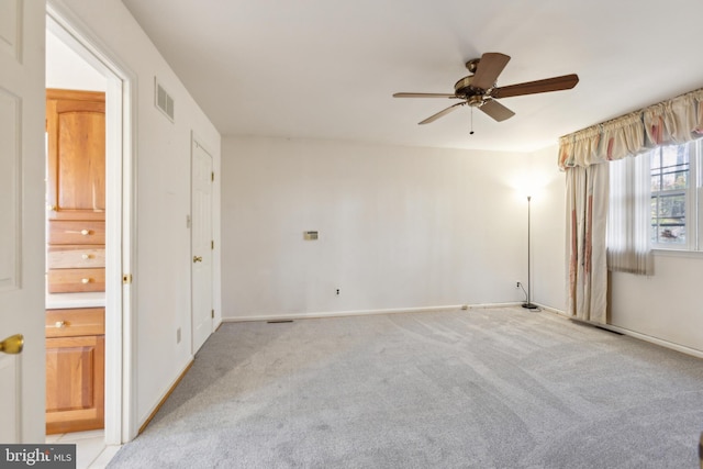 carpeted spare room featuring ceiling fan