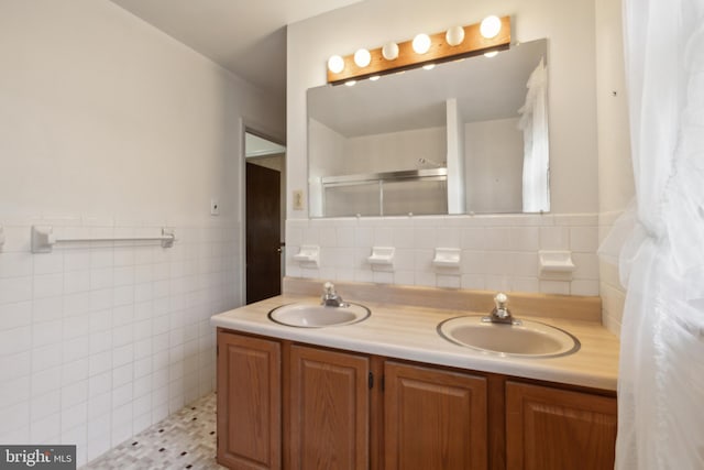 bathroom featuring tile patterned flooring, a shower, vanity, and tile walls