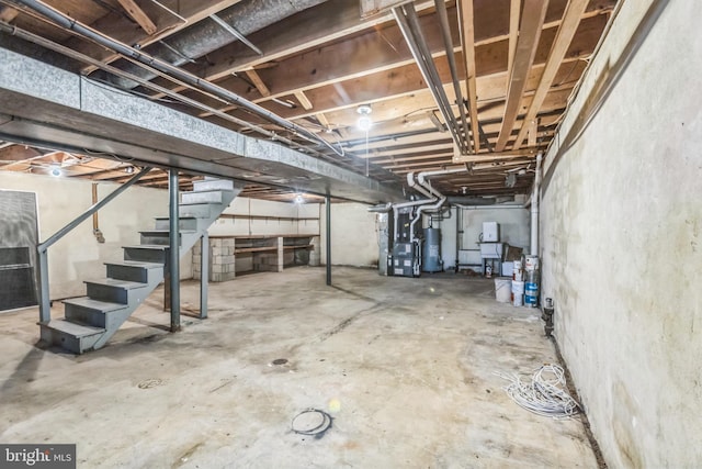 basement featuring heating unit and water heater