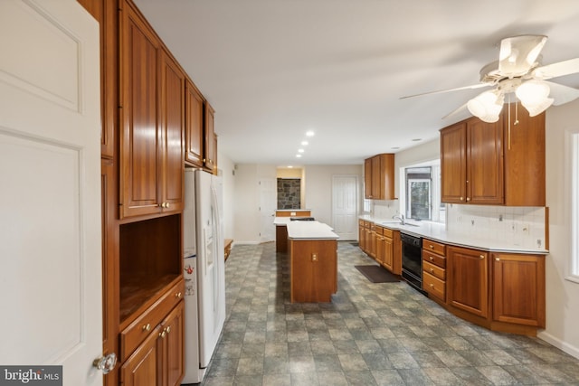 kitchen with backsplash, sink, ceiling fan, white fridge with ice dispenser, and a kitchen island