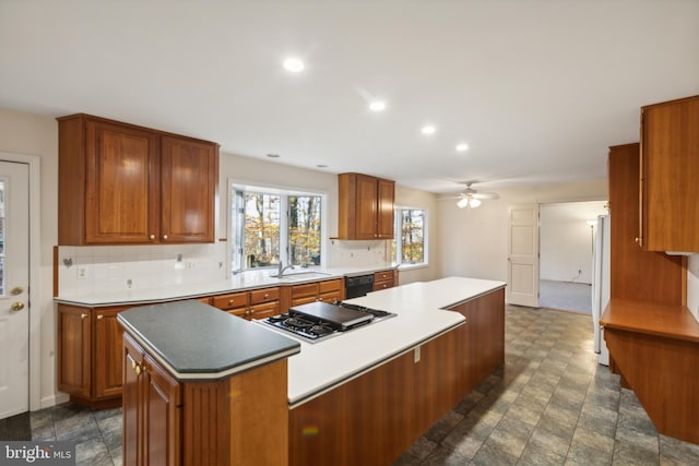 kitchen with ceiling fan, dishwasher, white fridge, a kitchen island, and stainless steel gas stovetop