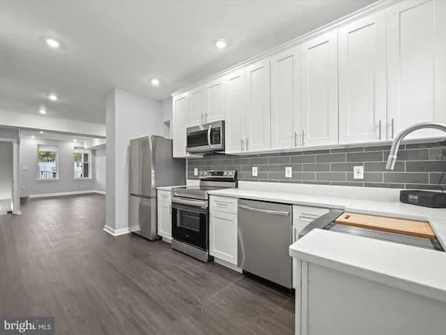 kitchen with sink, stainless steel appliances, tasteful backsplash, dark hardwood / wood-style floors, and white cabinets