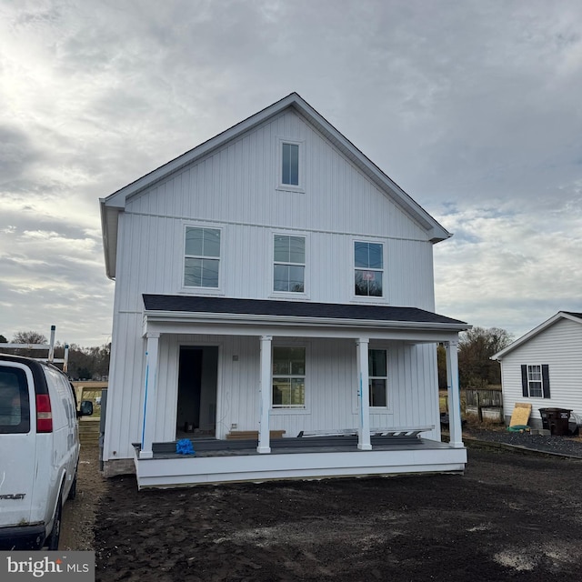 rear view of property featuring covered porch