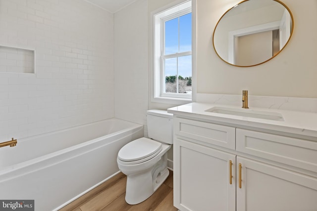 full bathroom with tiled shower / bath combo, vanity, hardwood / wood-style floors, and toilet