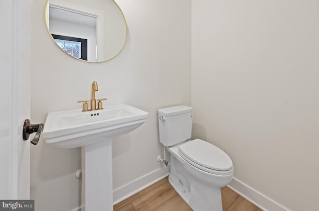 bathroom featuring sink, wood-type flooring, and toilet