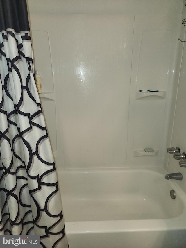 bathroom with shower / bath combo with shower curtain