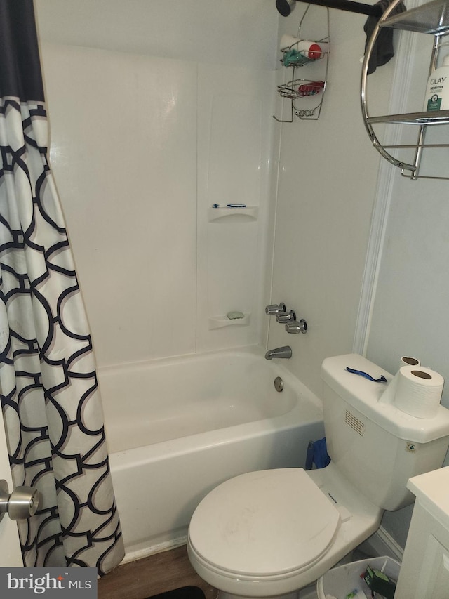 bathroom with hardwood / wood-style floors, shower / tub combo, and toilet