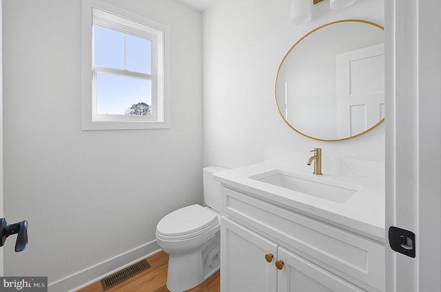 bathroom with wood-type flooring, toilet, and vanity