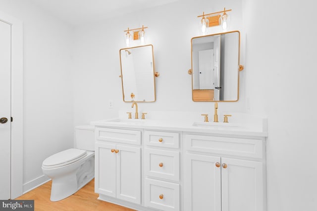 bathroom featuring toilet, vanity, and hardwood / wood-style floors