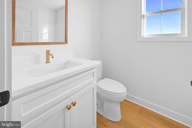 bathroom featuring wood-type flooring, toilet, and vanity