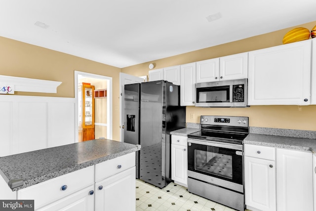 kitchen featuring stainless steel appliances, white cabinets, and a center island