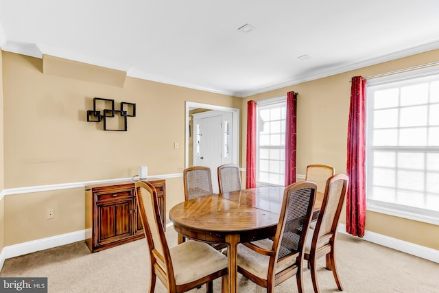 dining room featuring crown molding and light carpet