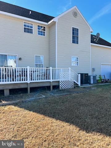 rear view of property featuring a yard, a wooden deck, and central air condition unit