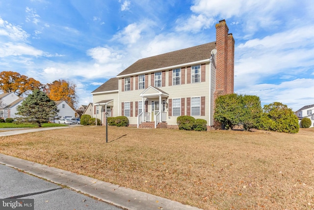 colonial inspired home featuring a front lawn