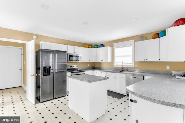 kitchen featuring sink, stainless steel appliances, a center island, and white cabinets