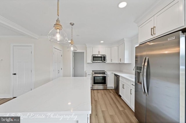 kitchen with white cabinetry, hanging light fixtures, and stainless steel appliances