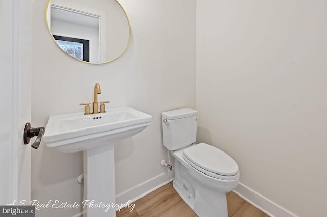 bathroom featuring wood-type flooring, toilet, and sink