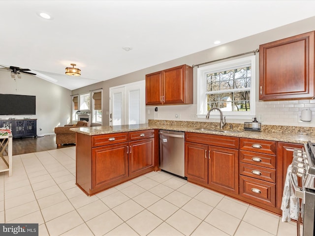 kitchen with sink, stainless steel dishwasher, ceiling fan, light stone countertops, and kitchen peninsula