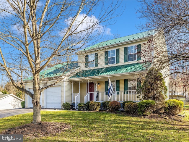 view of front of house featuring covered porch, a garage, and a front yard