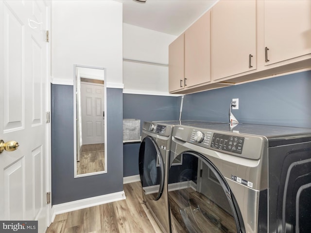 laundry room featuring cabinets, light hardwood / wood-style flooring, and washer and dryer