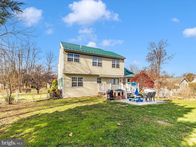 rear view of house with a lawn, a patio area, and a wooden deck