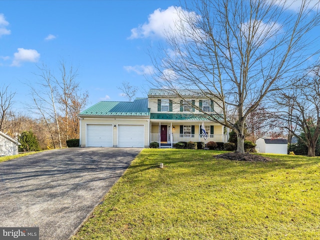 view of front of home featuring a garage, covered porch, and a front lawn