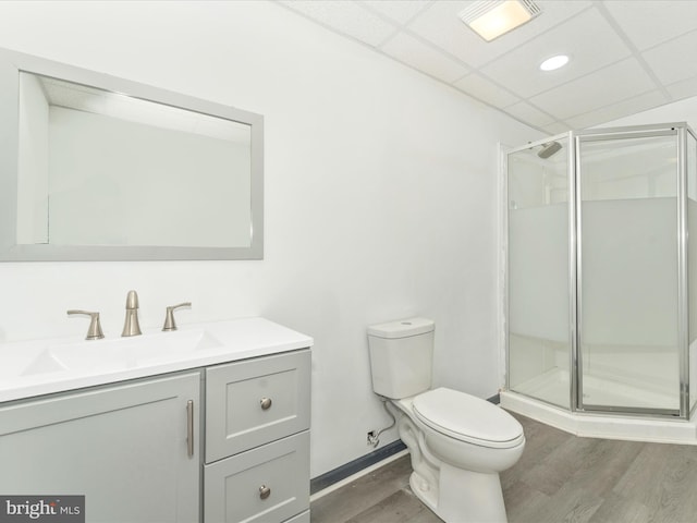 bathroom with toilet, a shower with door, and hardwood / wood-style flooring