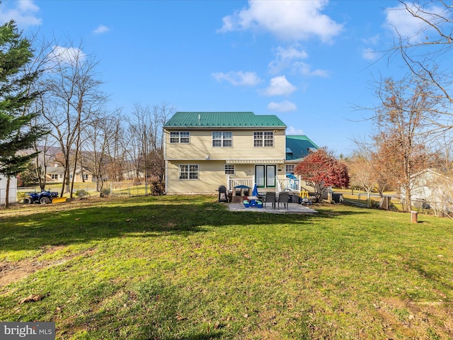 back of property with a lawn and a patio